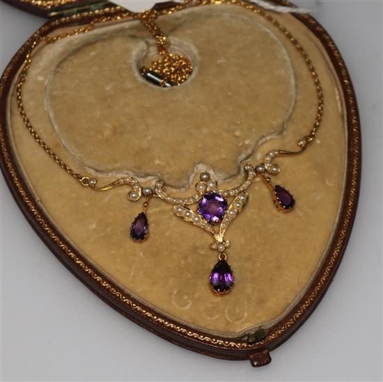 An Edwardian 15ct gold necklace hung with four amethysts and set with seed pearls, 18in.